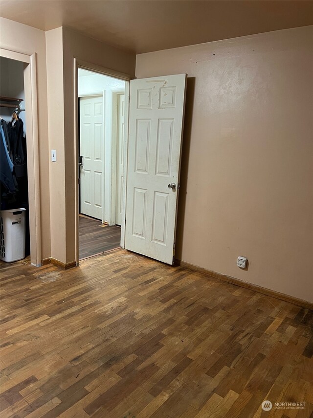 unfurnished bedroom featuring dark hardwood / wood-style floors and a closet