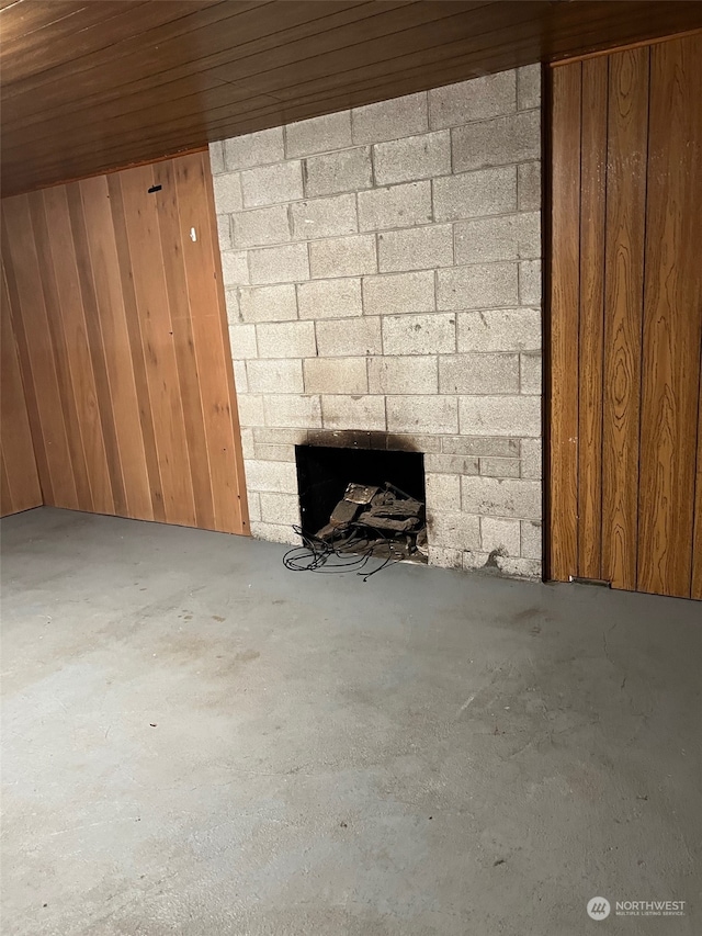 interior space with wooden walls, concrete floors, and wood ceiling