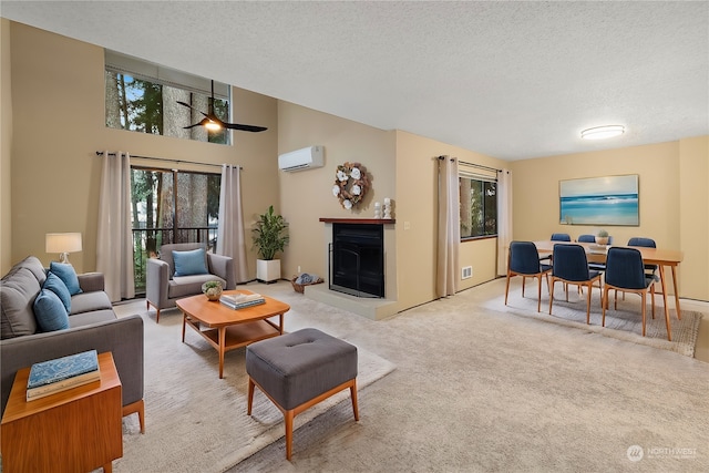 carpeted living room with a wall mounted air conditioner, ceiling fan, a towering ceiling, and a textured ceiling