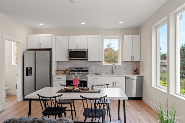 kitchen with plenty of natural light, white cabinetry, sink, and appliances with stainless steel finishes