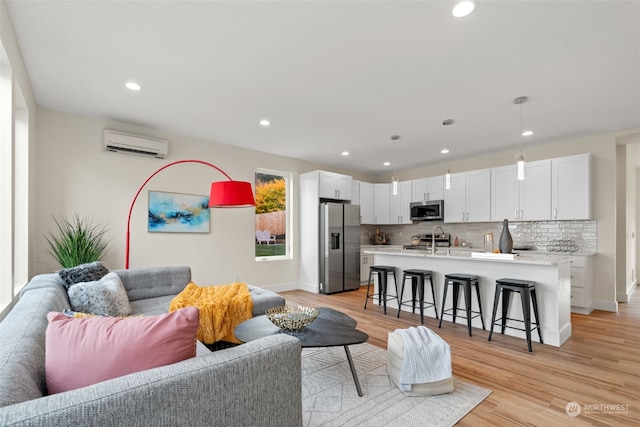 living room featuring light hardwood / wood-style flooring and a wall unit AC