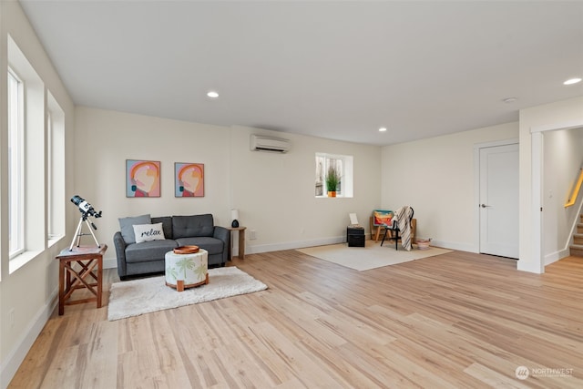 living area with light hardwood / wood-style floors and an AC wall unit