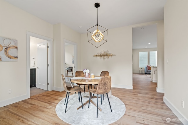 dining room with a notable chandelier and light wood-type flooring