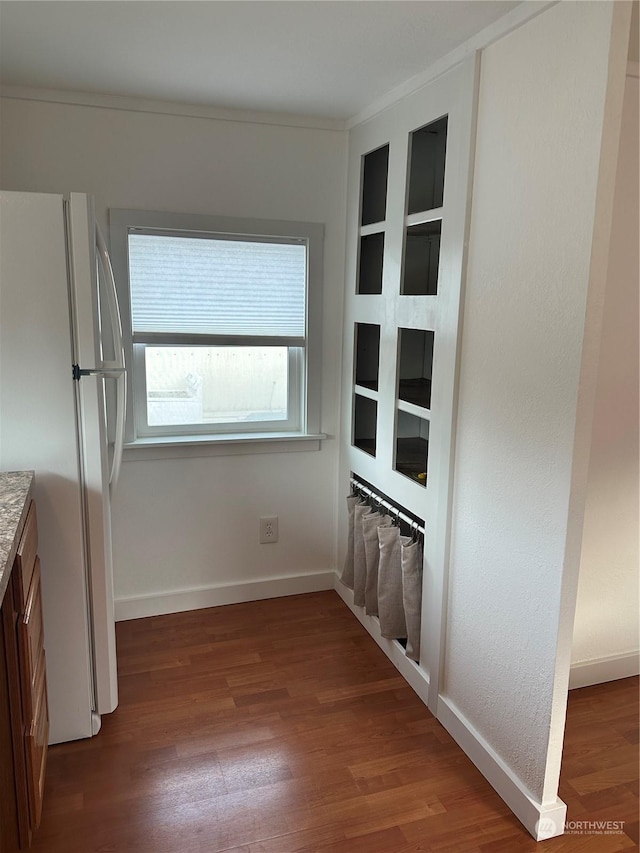 kitchen featuring hardwood / wood-style floors, white fridge, and ornamental molding