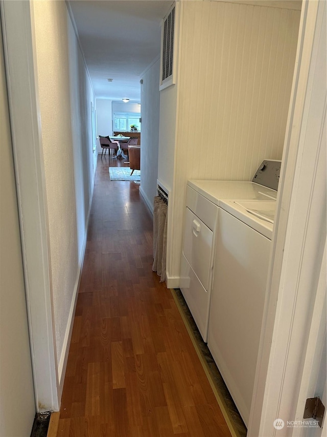 corridor featuring separate washer and dryer, radiator heating unit, dark hardwood / wood-style floors, and wooden walls