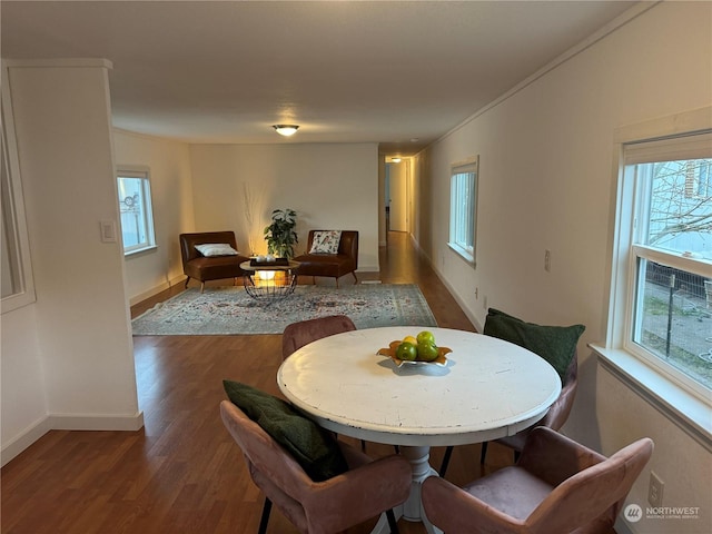 dining space with plenty of natural light and dark hardwood / wood-style floors