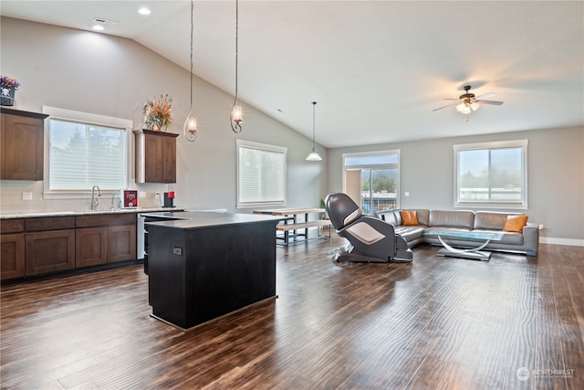 kitchen with dark hardwood / wood-style flooring, ceiling fan, pendant lighting, dishwasher, and a kitchen island