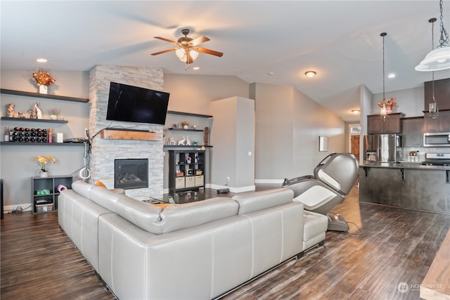 living room with dark hardwood / wood-style floors, ceiling fan, a stone fireplace, and lofted ceiling