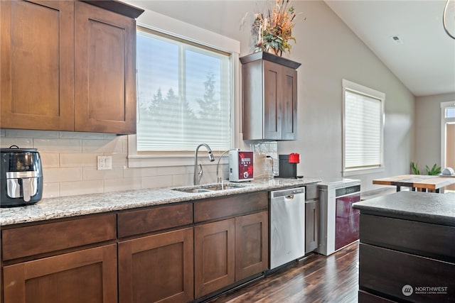 kitchen with dishwasher, sink, dark hardwood / wood-style flooring, vaulted ceiling, and decorative backsplash