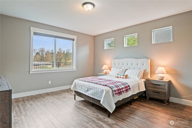 bedroom with wood-type flooring and multiple windows