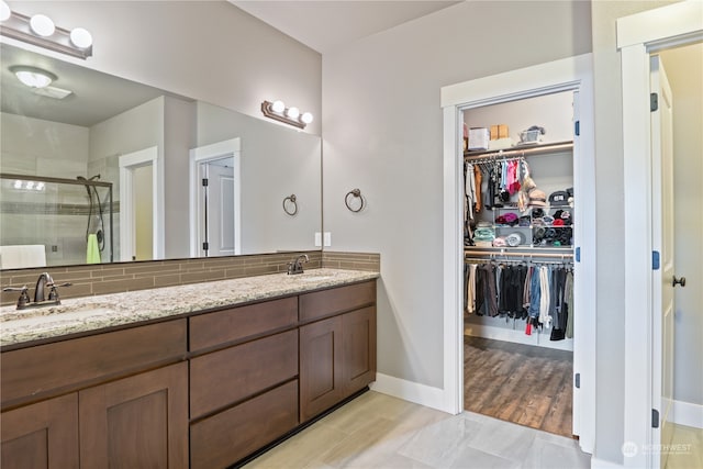 bathroom featuring backsplash, vanity, wood-type flooring, and an enclosed shower