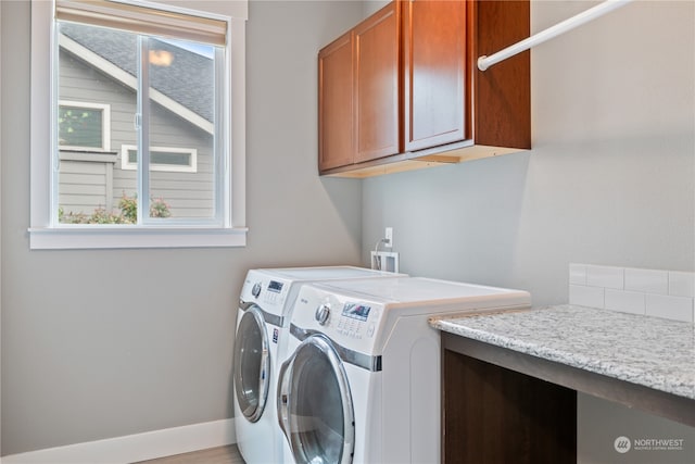 clothes washing area featuring cabinets and independent washer and dryer