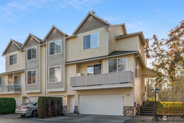 view of property featuring a garage and aphalt driveway