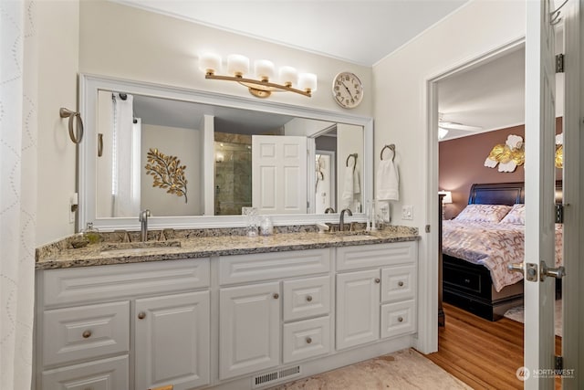 ensuite bathroom featuring visible vents, a sink, a shower stall, and ensuite bathroom