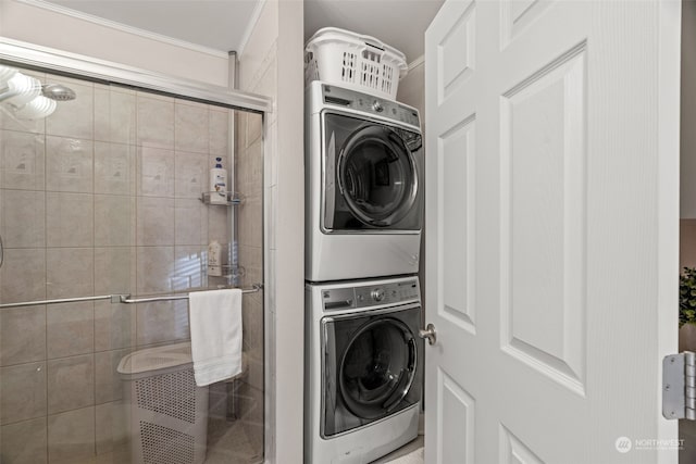 washroom featuring stacked washer and dryer and ornamental molding