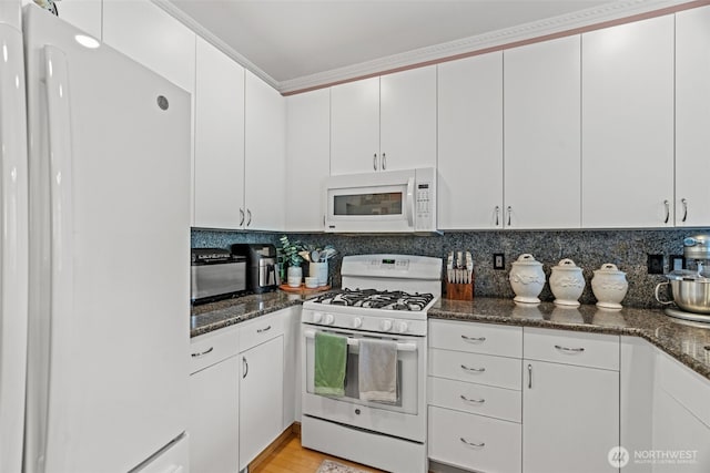 kitchen featuring white appliances, white cabinetry, and backsplash