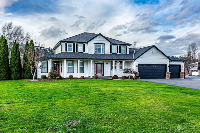 view of front facade with covered porch, a garage, and a front yard