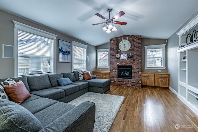 living room with light hardwood / wood-style floors, a wealth of natural light, lofted ceiling, and ceiling fan