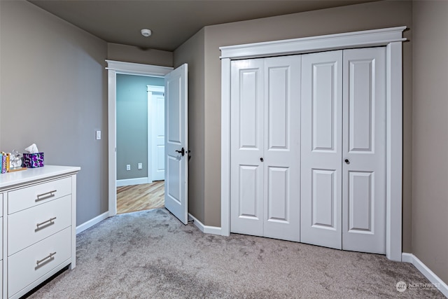 unfurnished bedroom featuring light colored carpet and a closet