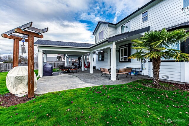 back of property with a patio and a lawn