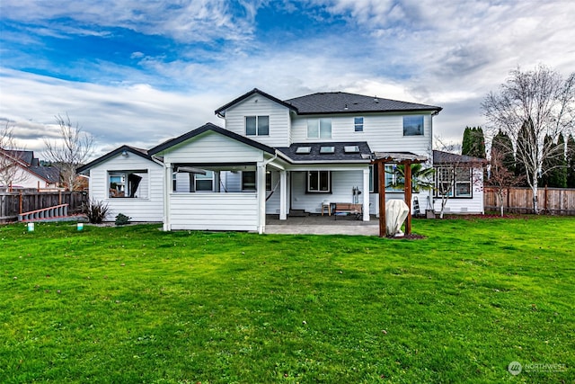 rear view of property featuring a lawn, a patio area, and a pergola