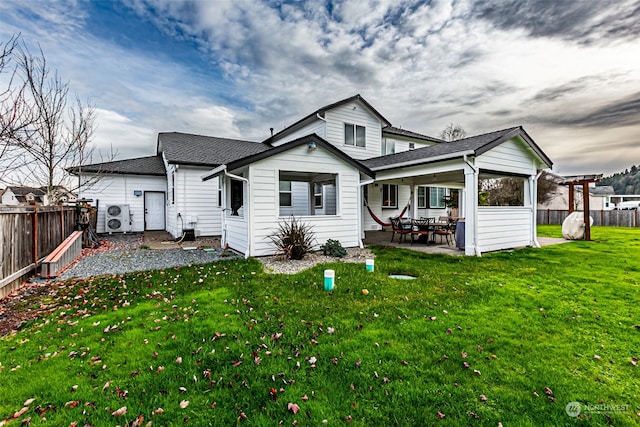 rear view of property with a pergola, a patio area, and a lawn