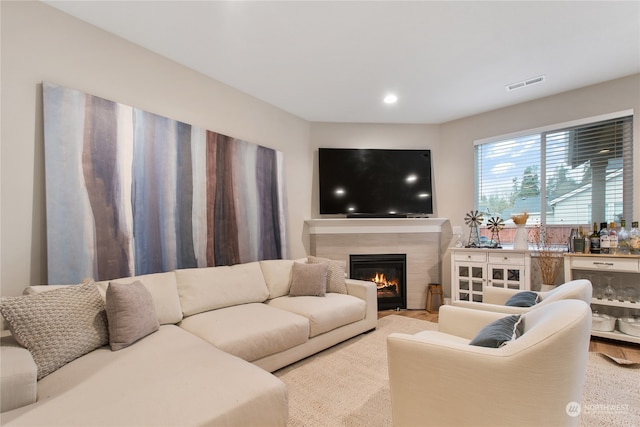 living room with a tile fireplace