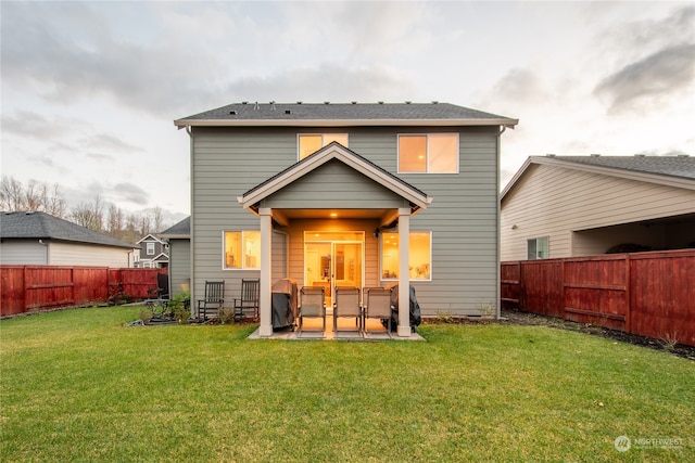 rear view of property with a patio and a lawn