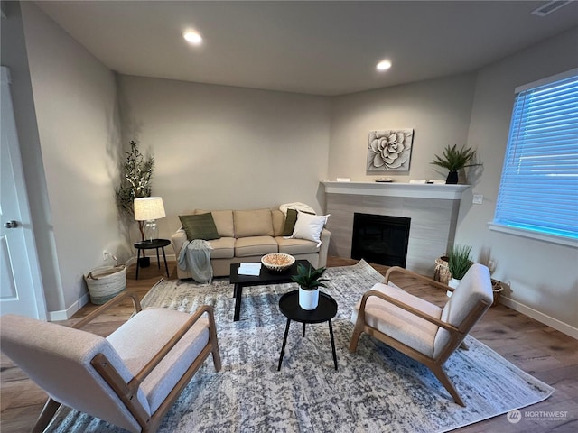 living room featuring hardwood / wood-style flooring and a tiled fireplace