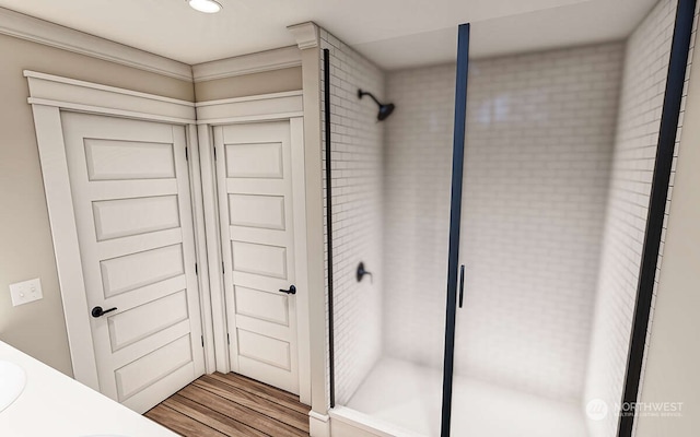 bathroom featuring hardwood / wood-style floors, vanity, and a shower with shower door