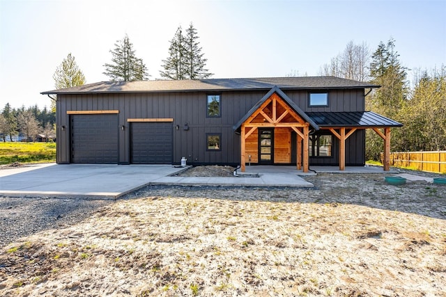 view of front of house with concrete driveway, fence, board and batten siding, and covered porch