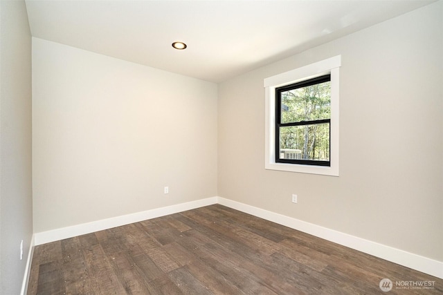 spare room with baseboards, dark wood-style flooring, and recessed lighting
