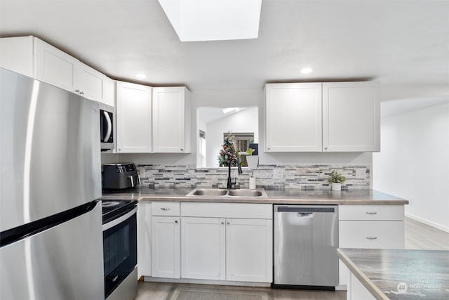 kitchen featuring white cabinets, appliances with stainless steel finishes, stainless steel counters, and sink