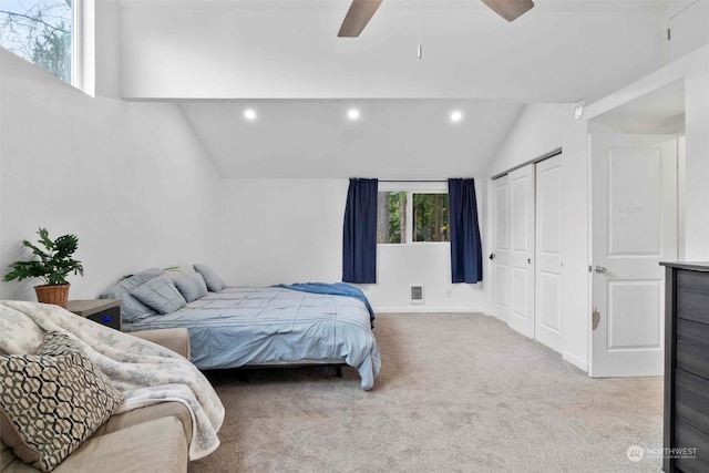 carpeted bedroom with a closet, ceiling fan, and lofted ceiling