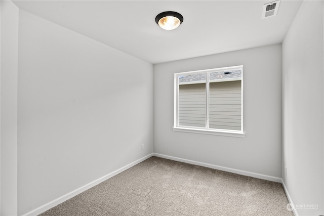 carpeted empty room featuring visible vents and baseboards