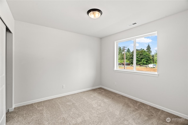 spare room featuring visible vents, baseboards, and carpet