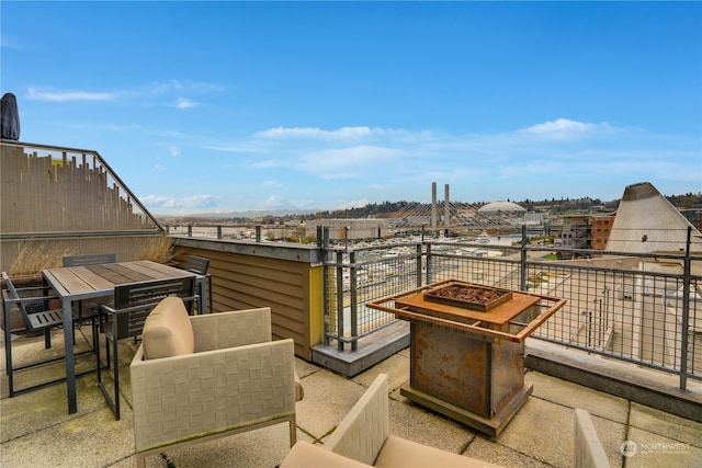 view of patio with a balcony and an outdoor fire pit