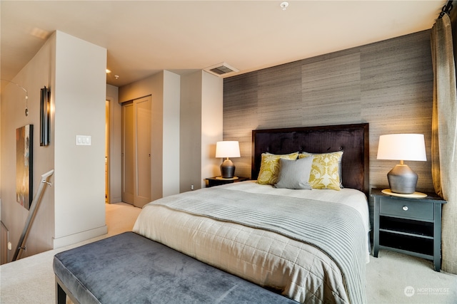 bedroom with light carpet and a closet