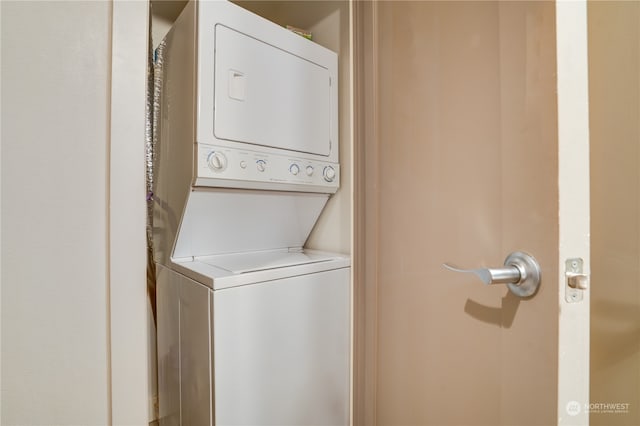 washroom with stacked washing maching and dryer