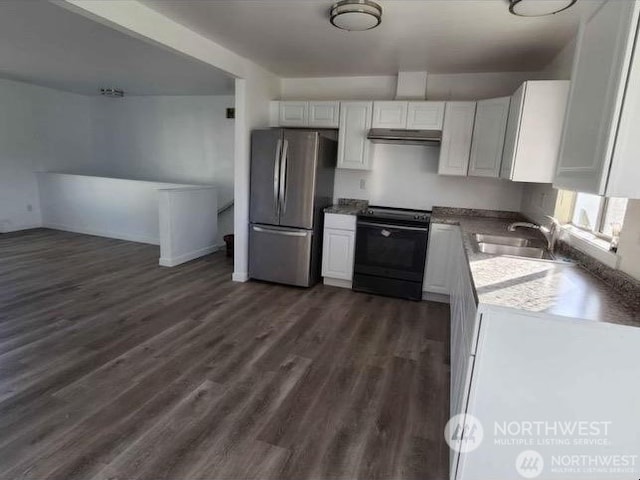 kitchen with black electric range oven, white cabinets, sink, dark hardwood / wood-style flooring, and stainless steel refrigerator