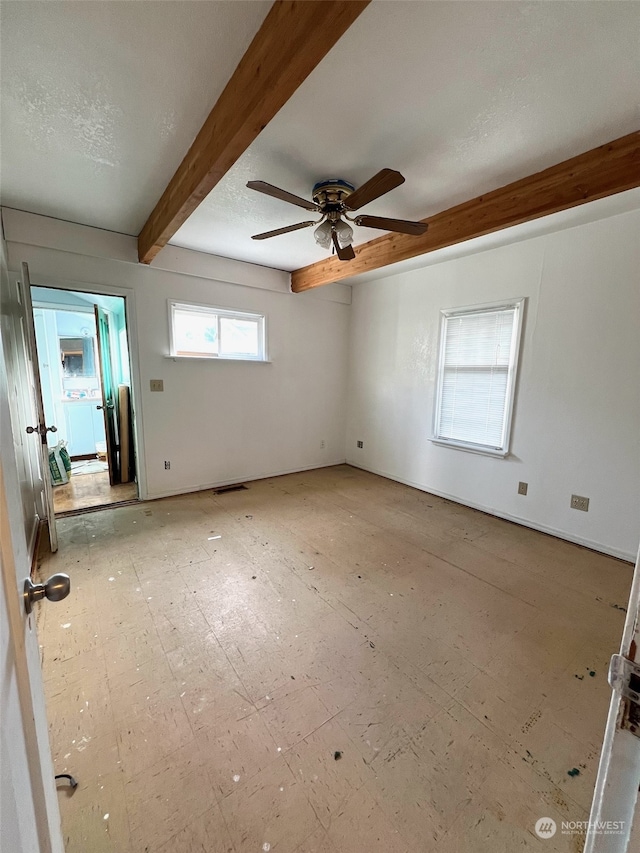 unfurnished room with ceiling fan, beam ceiling, and a textured ceiling