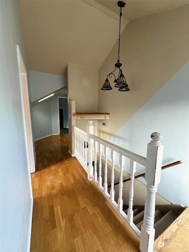 staircase with vaulted ceiling and hardwood / wood-style floors