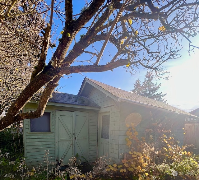 view of side of home with a storage shed