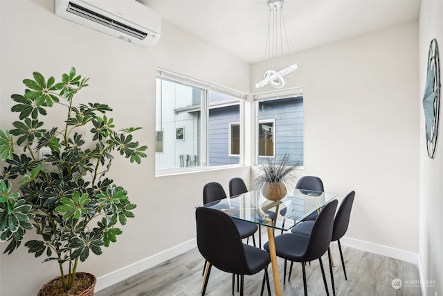 dining room featuring light hardwood / wood-style floors and a wall mounted air conditioner