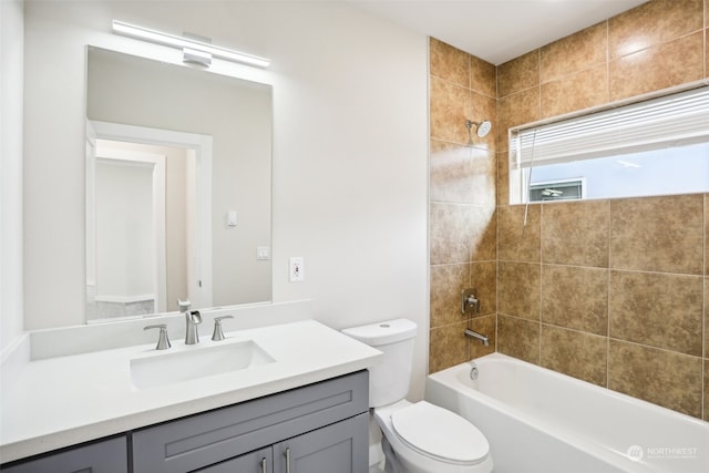 full bathroom with vanity, tiled shower / bath combo, and toilet