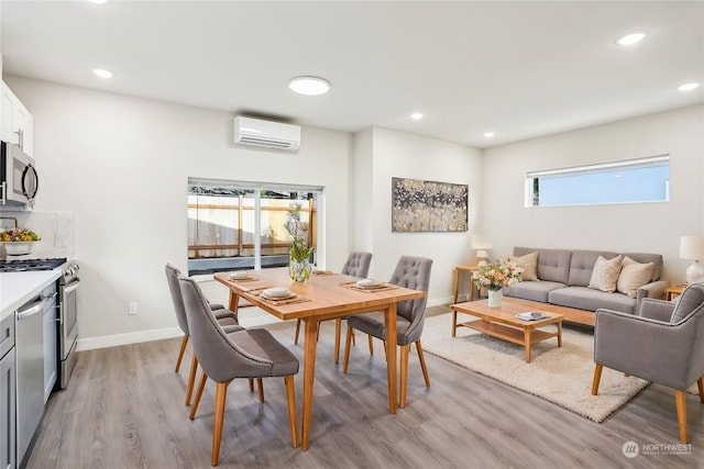 dining space featuring an AC wall unit, plenty of natural light, and light wood-type flooring