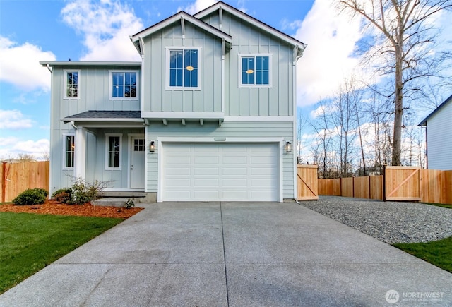 view of front of property featuring board and batten siding, concrete driveway, and fence