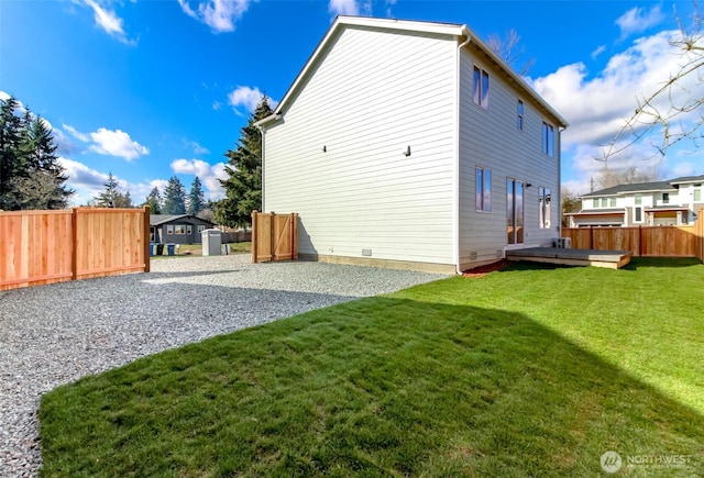 back of property with a yard, fence, and a wooden deck