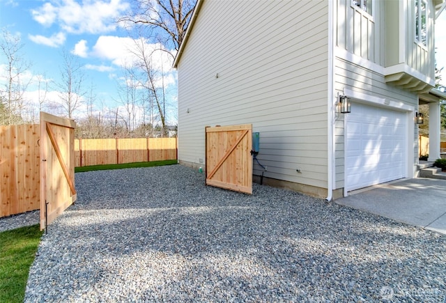 view of side of property featuring a garage and fence