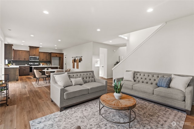 living room with light hardwood / wood-style floors and sink